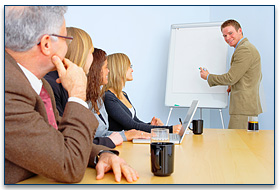 Image of several people in a meeting listening to the presenter